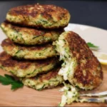 Courgette burgers met Parmezaanse kaas op een bord geserveerd.