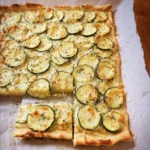 Courgette plaattaart met roomkaas, Parmezaanse kaas en knoflook op een bord