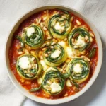 Ovenschotel met gevulde courgette rollen gevuld met spinazie en ricotta