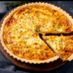 Quiche met groenten en feta mosterd op een bord.
