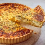 Vegetarische quiche met geitenkaas en groenten, mooi gepresenteerd op een bord.