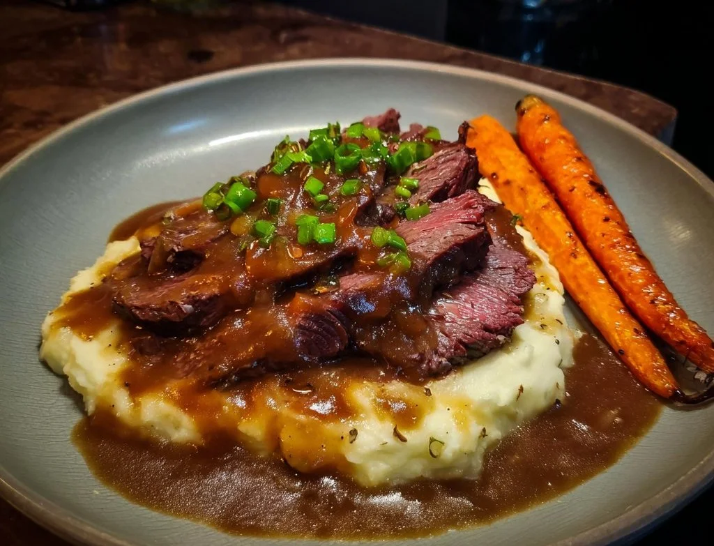 Ossenhaas met gekarameliseerde uiensaus en honing-tijm wortels op een bord.
