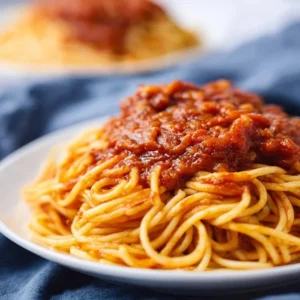 Een bord met gemakkelijke Chicago-stijl spaghetti, versierd met kruiden.